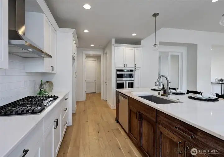 Kitchen, w/ 4-seat eat bar, quartz counters, engineered hardwood floors, built-ins and gas stove