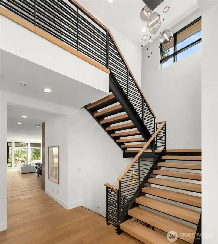Floating steel stairs create a bright and open entry. Home is also serviced by 3 floor custom Residential Elevator with custom wood paneling and hardwood floors