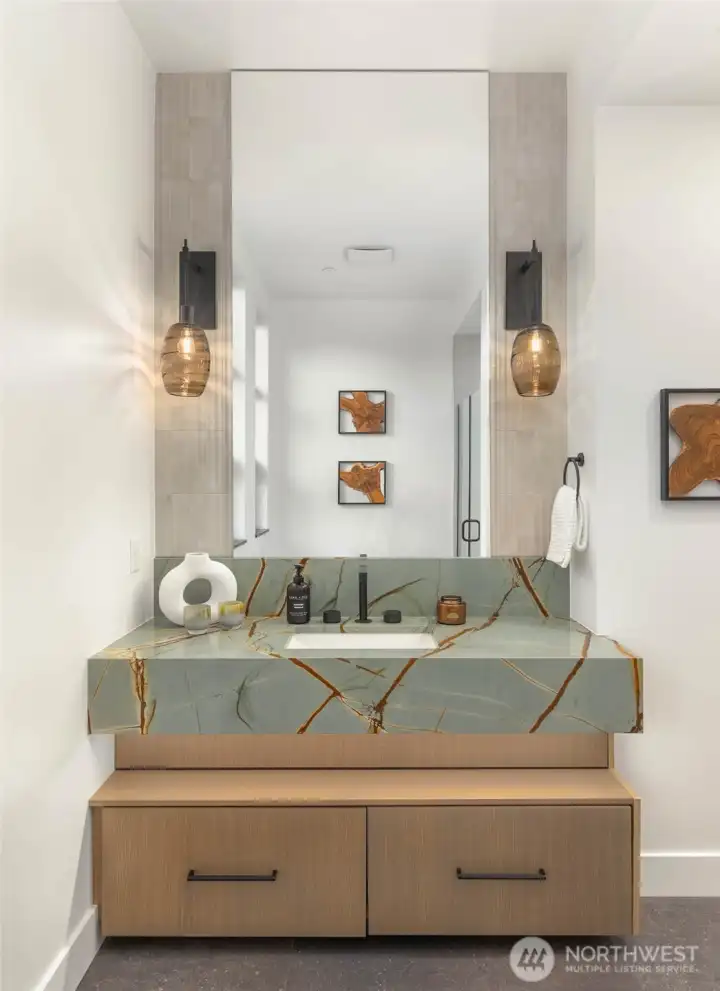 Stunning slab counter with custom cabinets and full height tile backsplash and mud set tile shower in 3/4 guest bath off entry and study