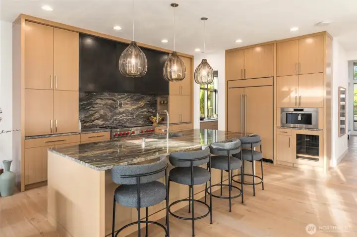 Seamless and luxurious kitchen. 48" side by side Sub Zero refrigerator and under counter Sub Zero Beverage Center both with matching custom wood panels. Wolf Series Professional Built in Coffee Maker takes coffee to another level