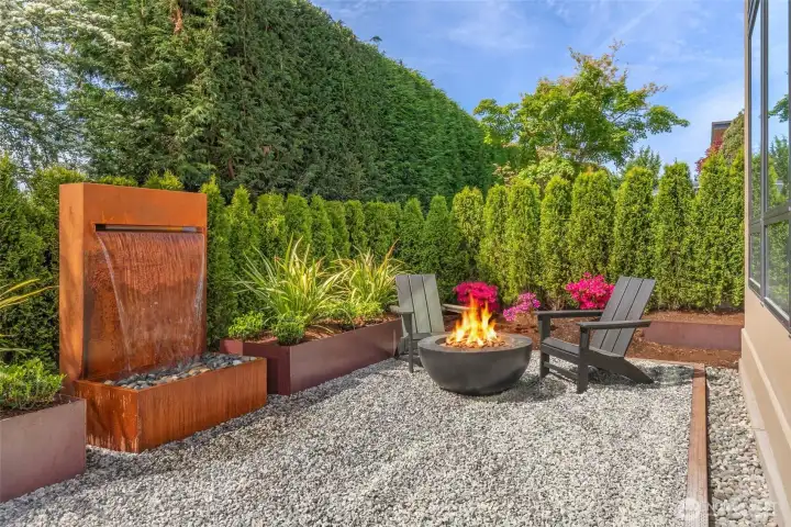 Zen Garden off deck with gas fireplace, custom steel water feature, and raised corten steel beds
