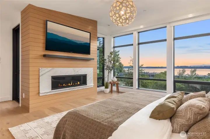 Primary Retreat highlighted by custom slab fireplace surround with floor to ceiling wood surround and steel mantel