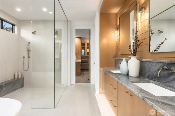 Grand walk in shower with duel heads, custom slab bench, and frameless crystal clear glass surround