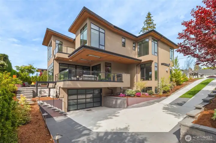 Large lower driveway for ease of access into sprawling 1200 Square Foot Epoxy coated 3+ Car Garage. Plenty of space to back out and drive up the hidden driveway