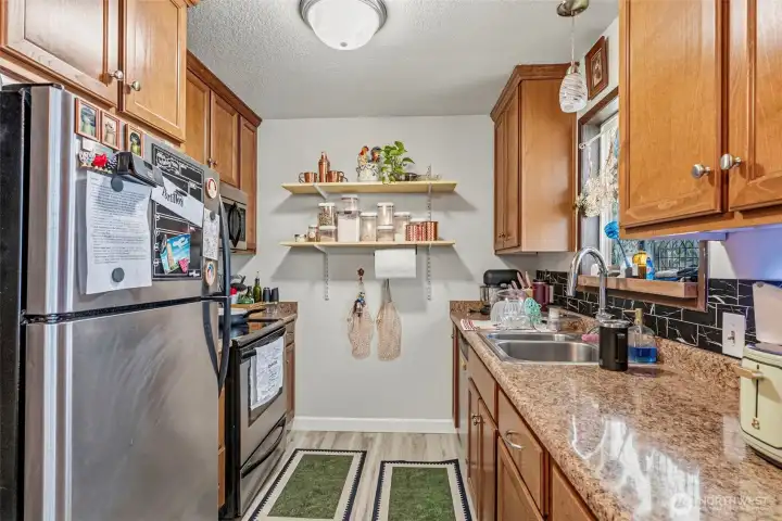 Modern updates throughout! This stylish galley kitchen boasts brand-new appliances, contemporary lighting, and pristine new flooring