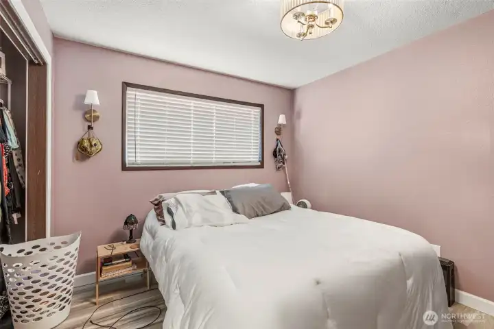 Comfortable second bedroom showcasing fresh modern paint, brand-new flooring, and an updated light fixture