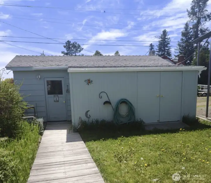Garage that has been used as a pottery studio; still has roll up door at right end of building