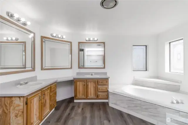 Primary bathroom has tons of counter space and new tile around tub