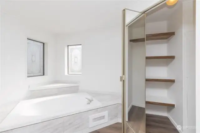 Additional linen storage closet in bathroom with mirrored doors