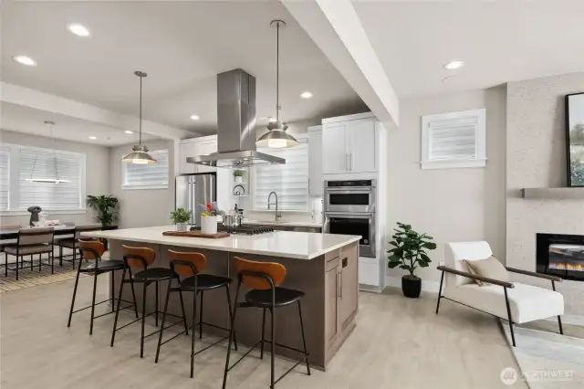 The kitchen is at the heart of the home featuring a large island with seating, pendant lights, a 5-burner gas cooktop with extraction hood, and thick slab quartz countertops.  The family room and dining room are flanked on both sides of the kitchen.