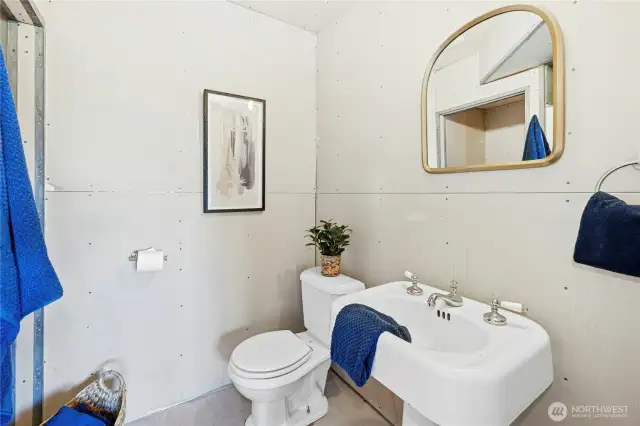 Lower level 3/4 bath with shower. All functional fixtures, but final surface work needed.