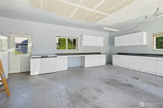 Oversized 2 car garage with built in cabinets, chest freezer and pull-down attic storage stairs