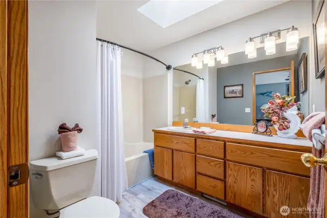 Primary bathroom includes plenty of counter space and a tb/shower.