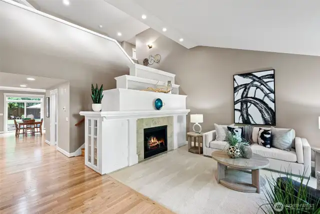 A wide hallway with gleaming hardwood floors leads to the dining room and great room beyond.