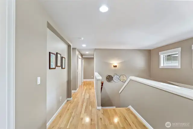 The gleaming hallway leads to the bedrooms, bonus room, utility room, and bath.