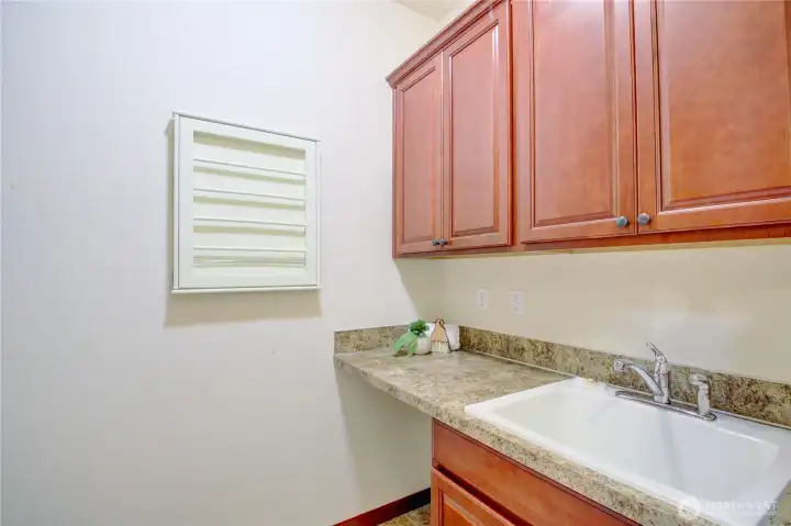 Laundry room with deep sink, great storage and convenient to the primary bedroom.