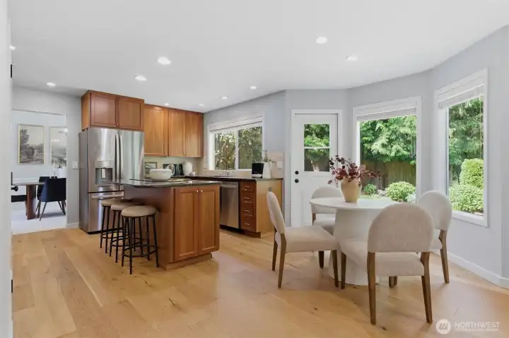 Warm, bright kitchen and dining space featuring an open layout with beautiful garden views.