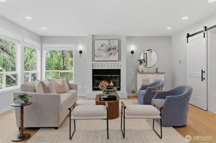 Bright family area with cozy fireplace looks onto manicured yard and patio with view of retention pond that offers privacy!