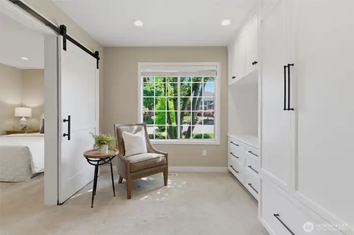 Main floor suite features a bright sitting room with custom cabinets, a large bedroom with closet built ins, and a stunning 3/4 bath - ideal for multigenerational living or extended guest stays.