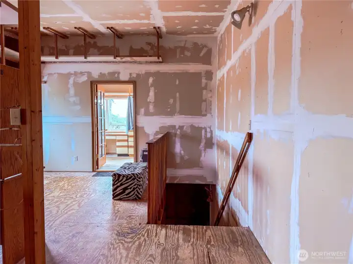 Stairs in unfinished room lead to garage