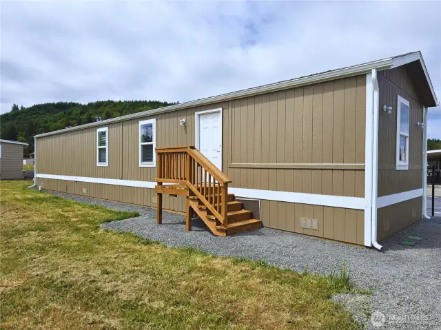 Clean and welcoming exterior—fresh paint, new porches, skirting, and gutters.