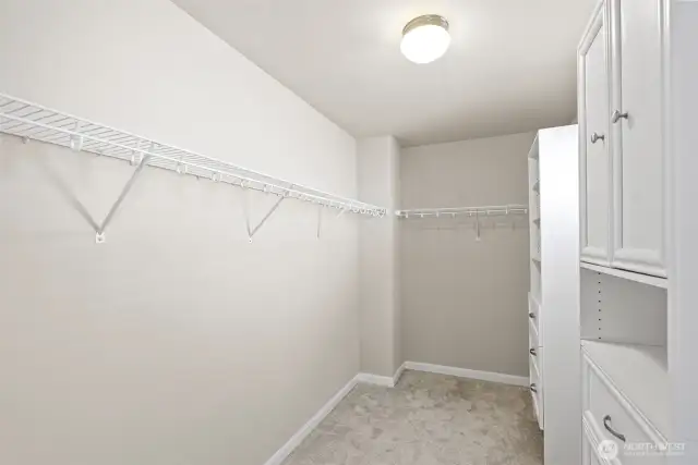 Large primary closet with built in cabinetry
