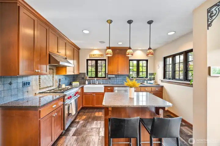 Kitchen island offers additional eating space in this rich kitchen with warm, cherry cabinets and fireclay apron sink.