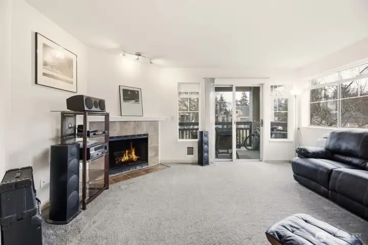Spacious living room with lots of windows, a slider to the covered porch and a cozy wood burning fireplace.