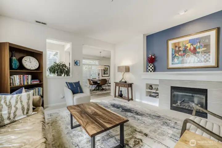 The accent wall spotlights artwork above the gas fireplace with its wide mantle and inset bookcases on each side.