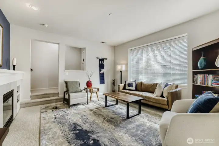Another view of the living room with the large picture window and the entrance to the staircase to the upper floor.