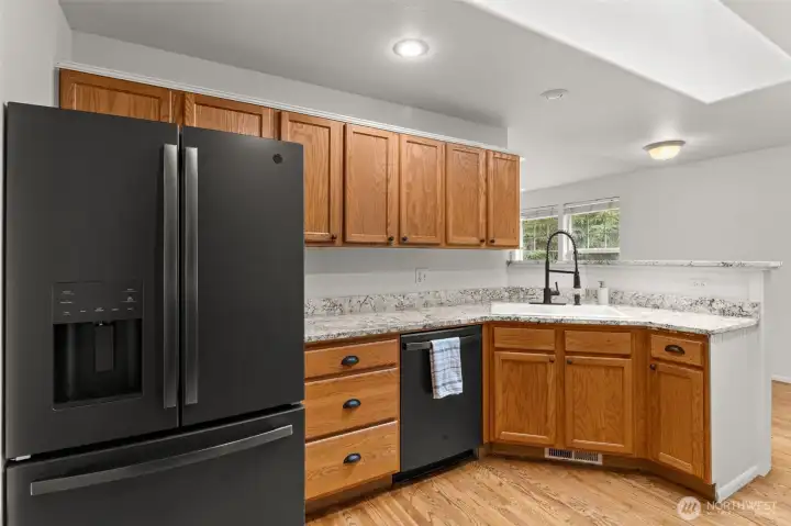 The kitchen offering ample cabinet storage, functional workspace, and easy flow into the dining and breakfast areas.