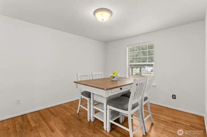Dining room with hardwood floors and space for gathering with friends and family, dining set may stay with the home