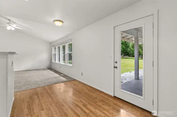 Bright breakfast nook with hardwood floors and peaceful backyard views, creating the perfect spot for morning coffee or casual dining