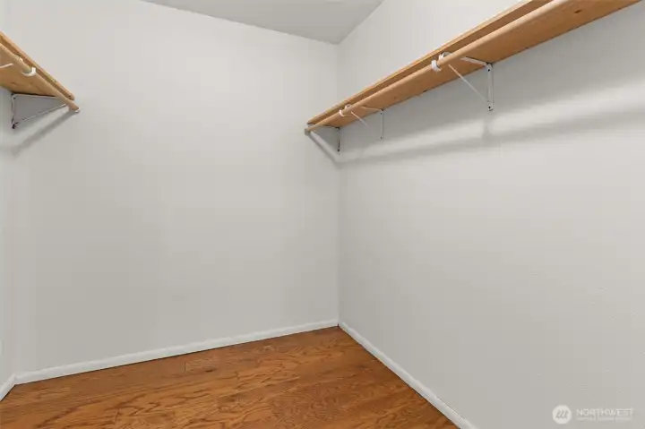 Spacious walk-in closet featuring hardwood floors and room for wardrobe organization