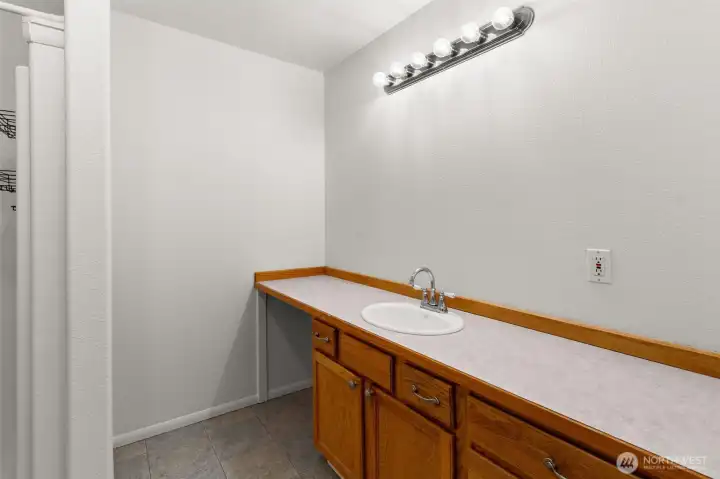 Primary bath with a window for natural light, extended countertop with sitting area, and plenty of space for daily routines and soaking the stress away.