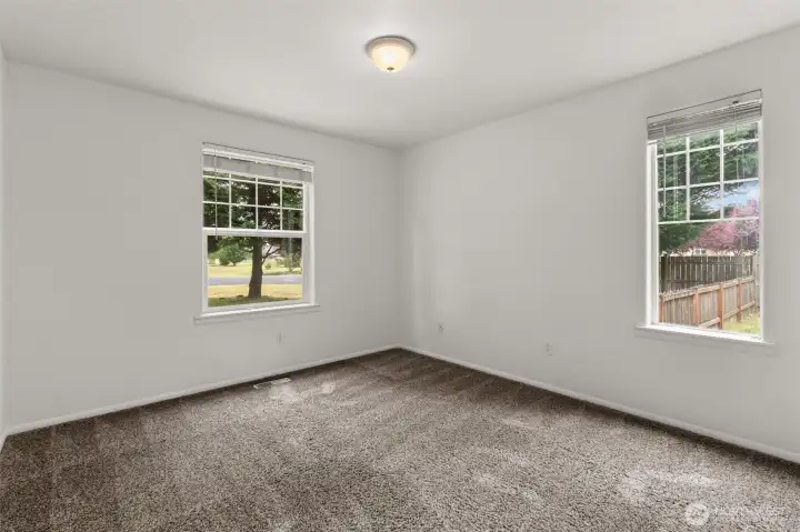 Bedroom 2 of 3 overlooking the front yard with natural light and comfortable space for guests or maybe the perfect home office.