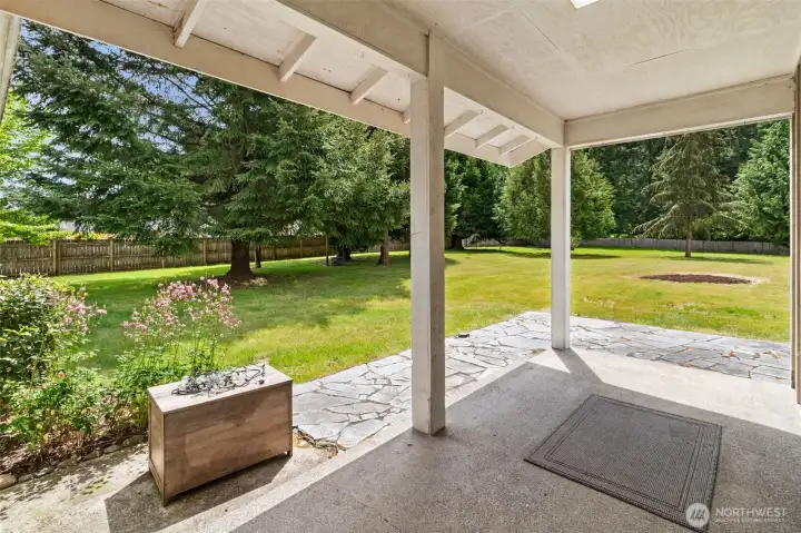 Covered back porch perfect for sitting, relaxing, and enjoying views of the beautifully landscaped backyard year-round.