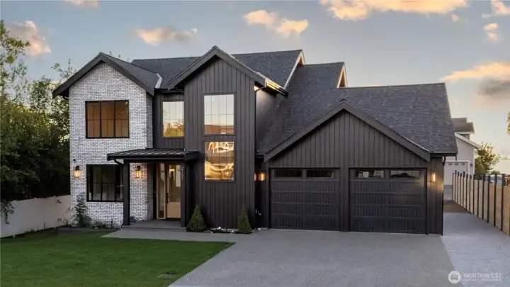 Whitewashed brick facade, James Hardie Artisan V-Groove siding, and oversized two-car garage.
