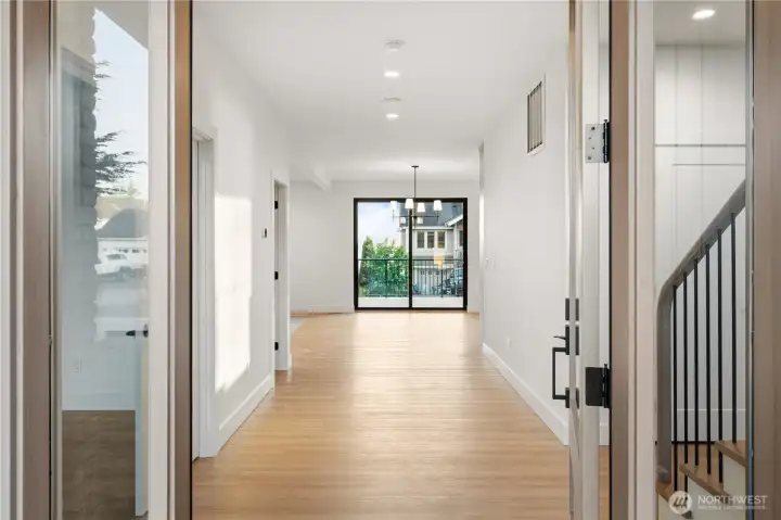 Bright entry hall opens to the dining room with deck access and harbor views beyond.