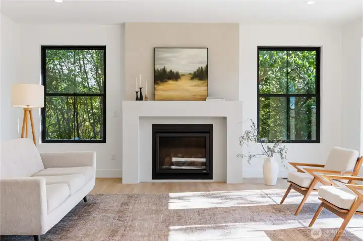 Great room with Venetian plaster gas fireplace, abundant natural light, and treetop views from every window.