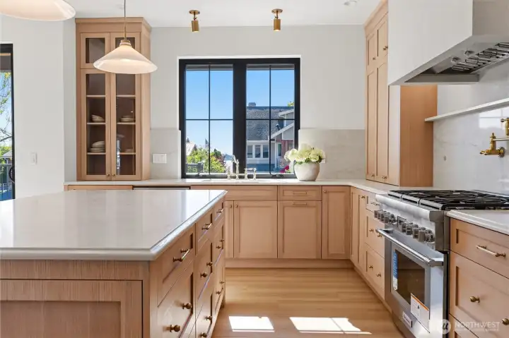 Chef's kitchen with Thermador range, MSI SoliTaj quartz counters, and harbor views from the sink.