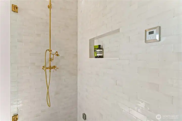 Delta steam shower with zellige-style tile, heated marble bench, and floors.