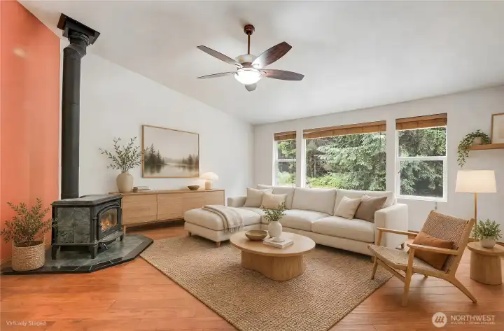 The living room enjoys lots of natural light, a toasty woodstove and vaulted ceilings. This room is virtually stageg.