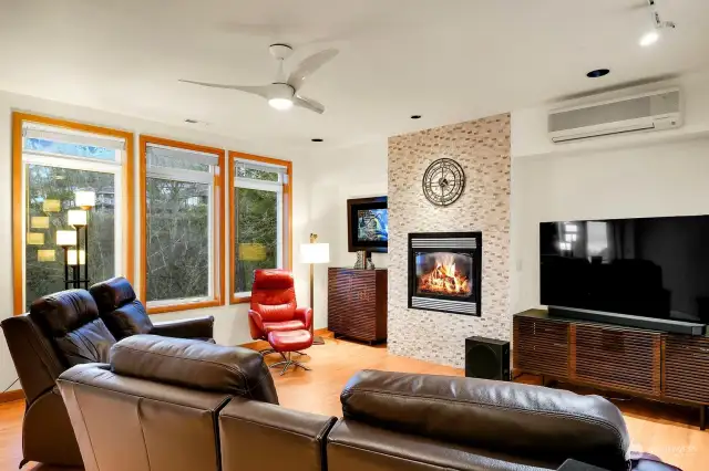 This cozy family room features a gas fireplace surrounded by stacked stone, a ceiling fan for added comfort, and a mini-split system to keep you cool during hot summers.