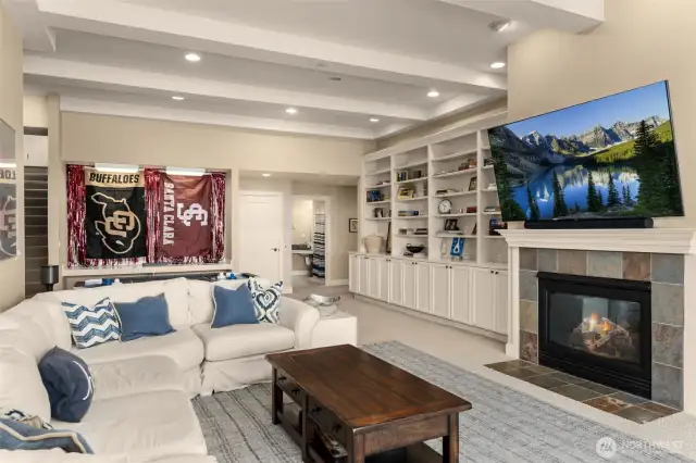 Spacious recreation room with fireplace and built in shelves.