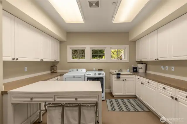 Large laundry room with plenty of cabinets and walk in closet.