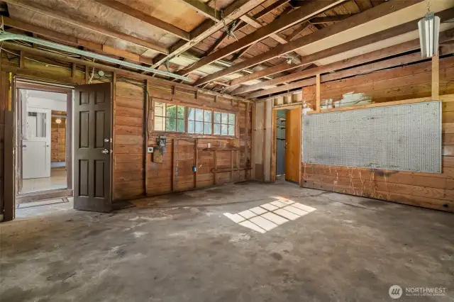 Garage with door leading to the back storage room perfect for off-season storage or extra hobbies.