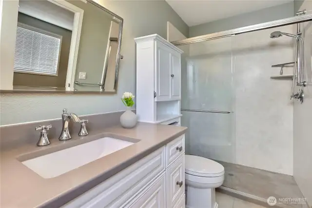 Primary ensuite bath, tastefully updated! I love the solid-surface counter and walk-in shower, not to mention that amazing larger mirror.
