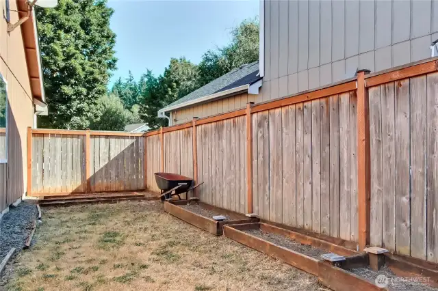 Side yard view, freshly landscaped, wheel barrow stays!