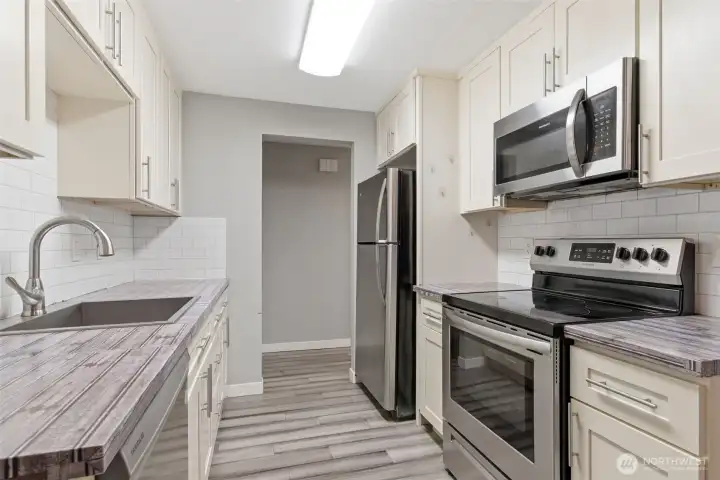 Updated kitchen has newer stainless appliances that stay with the home.